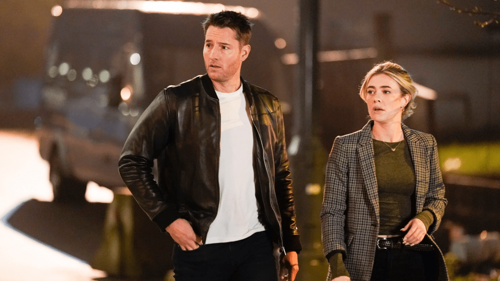 A still from TV show Tracker season one featuring a man (Justin Hartley as Colton Shaw) in a black leather jacket and white t-shirt walking next to a blond woman (Melissa Rxburgh as Dory Shaw) wearing a black-stripped blazer in an empty street. They are both looking to their right with a puzzled expression