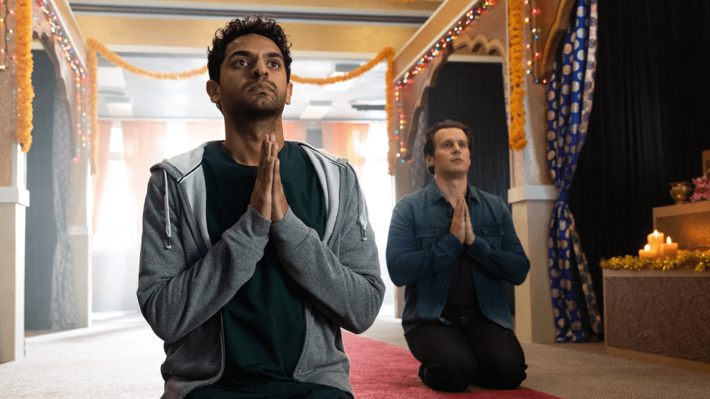 Karan Soni, and Jonathan Groff in A Nice Indian Boy, both kneeling with their hands together in prayer.