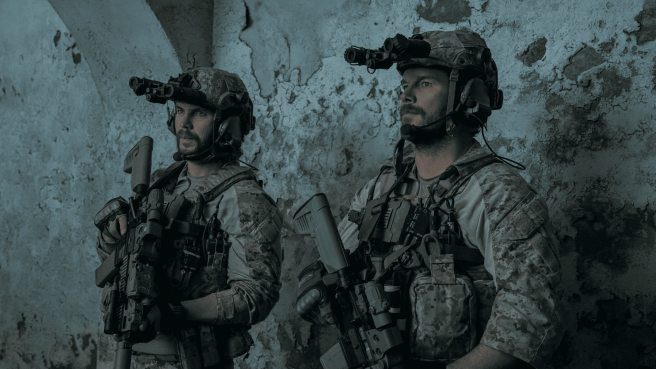 Chris Pratt and Taylor Kitsch in The Terminal List: Dark Wolf (2025), both men in navy SEAL battle uniform with helmet and machine guns.