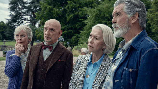 Four elderly people (two men and two women) outside an English estate, all looking puzzled at something outside of the frame.