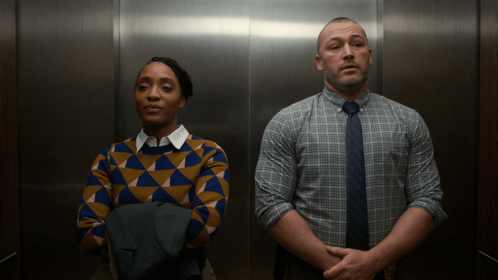 Agent Faith Mitchell (Iantha Richardson) and detective Michael Ormewood (Jake McLaughlin) stand side by side in a quiet elevator, their contrasting expressions hinting at unspoken tension. a scene from Will Trent season 3.