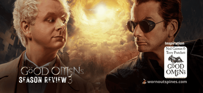 Micheal Sheen as Aziraphale with blond curly hair in a light-colored suit and bow tie, and David Tennant as Crowley with dark hair wearing goggles and a dark jacket in Good Omens season 3.